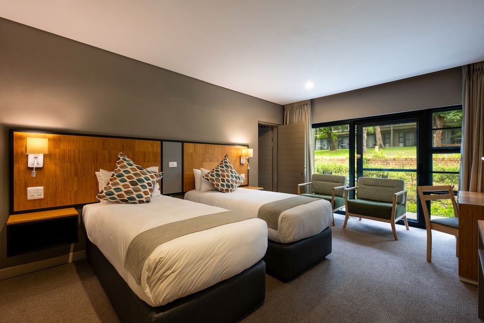 A lodge room with two beds and garden views.