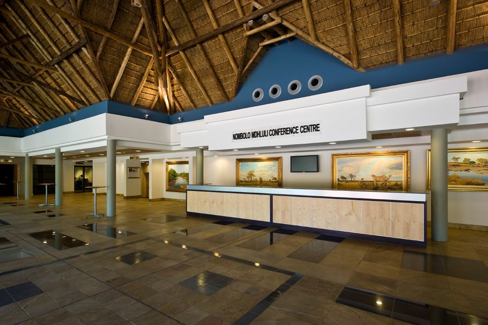 The foyer and entrance of the conference centre under a thatched roof.