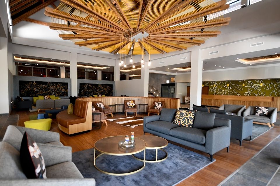 A lounge with sofas under a timber ceiling.